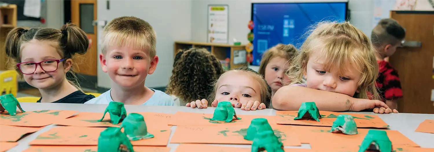 Preschoolers working on art projects at a table in a Dawson-Bryant classroom.