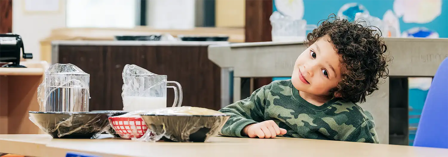 A young child at a classroom activity table at the Getaway site.