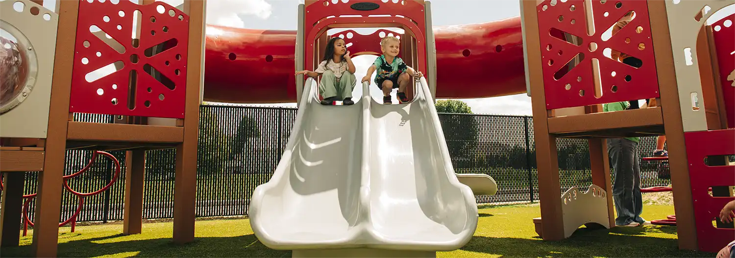 Two children at the top of a double slide on the Proctorville playground.