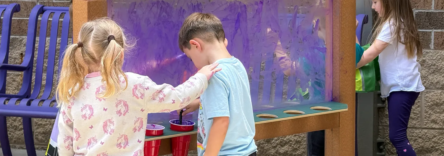 Children painting at an outdoor art station at South Point Elementary.