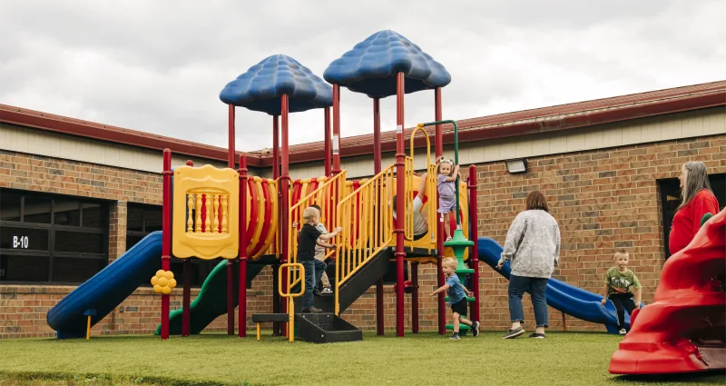 Children playing on the colorful playground at the Symmes Valley site.
