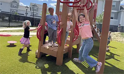 Preschoolers playing together on outdoor playground equipment